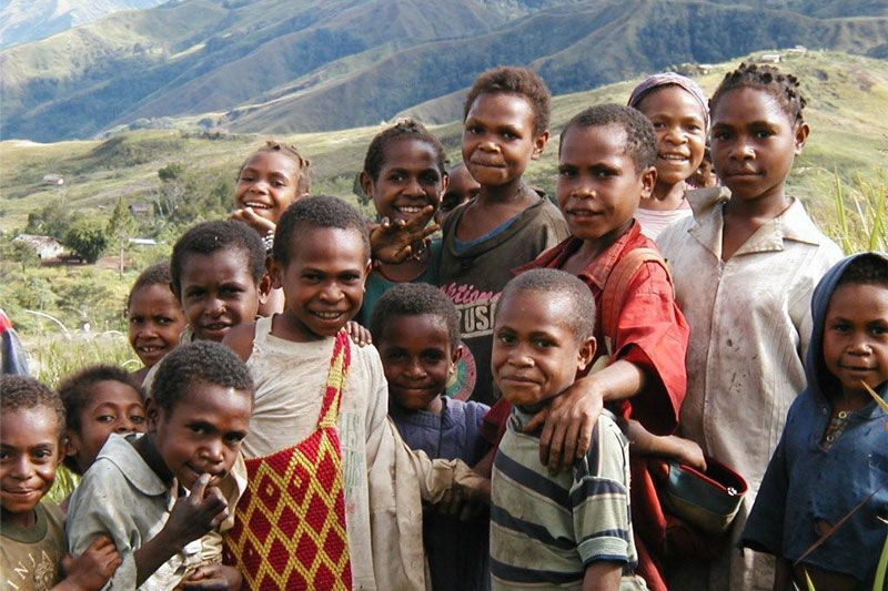 Papua New Guinea group of smiling children and mountains in the background